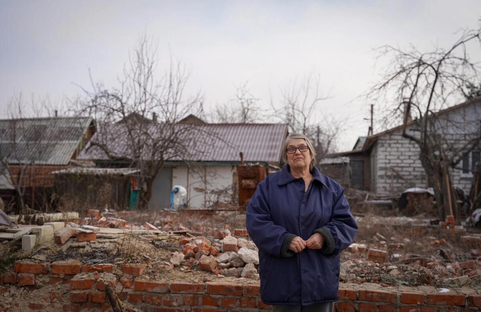 a portrait of a woman in front of the destroyed building