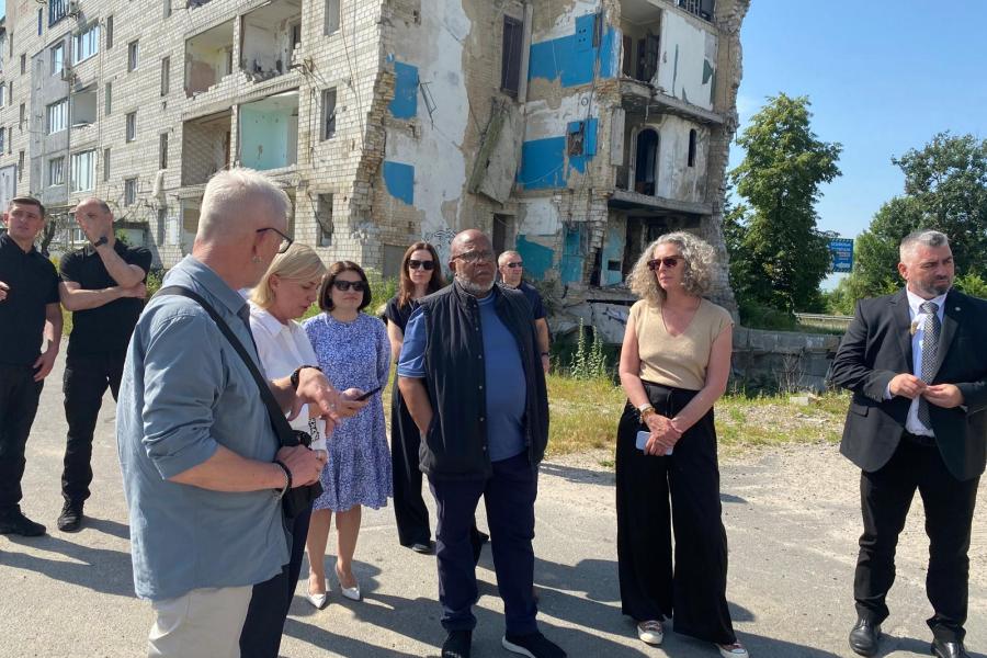 Picture with the President of the UN General Assembly and a group of people in front of a destroyed building in Borodyanka, Kyiv Region